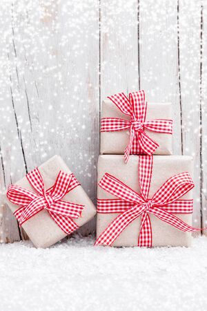 Christmas presents with snow on grey wooden backgroundの写真素材