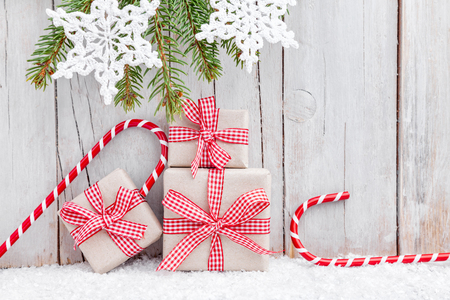 Christmas presents with snow on grey wooden backgroundの写真素材
