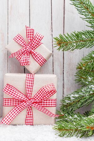 Christmas presents with snow on grey wooden backgroundの写真素材