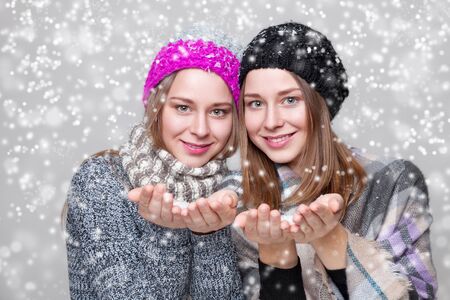 Portrait of twin sisters dressed in warm winter clothesの写真素材