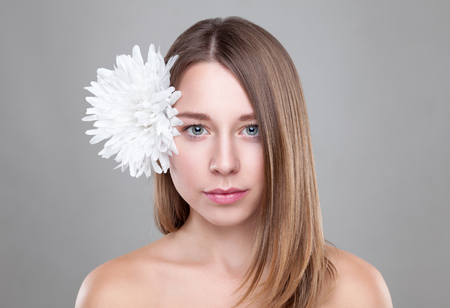 Beautiful brunette woman with a white flower in hairの写真素材