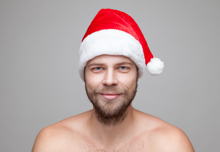 Portrait of a handsome man with beard wearing a Christmas hatの写真素材