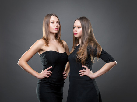 Studio portrait of twins dressed in black dressesの写真素材