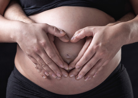 Portrait of young and delighted parents expecting a baby