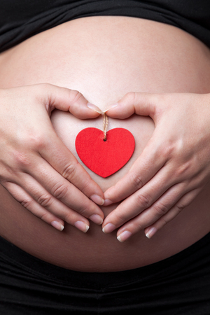 Portrait of a pregnant woman holding her bellyの写真素材