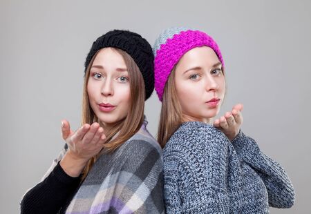 Portrait of twin sisters dressed in warm winter clothesの写真素材