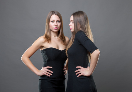 Studio portrait of twins dressed in black dressesの写真素材