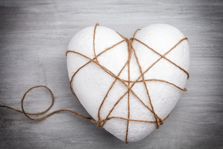 Heart bound by a string on grey rustic backgroundの写真素材