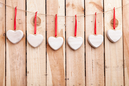 Love concept. Hearts hanging on a string, shot on wooden backgroundの写真素材