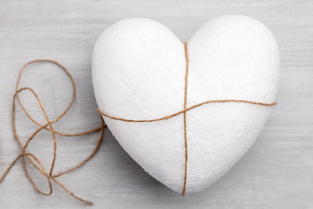 Heart bound by a string on grey rustic backgroundの写真素材