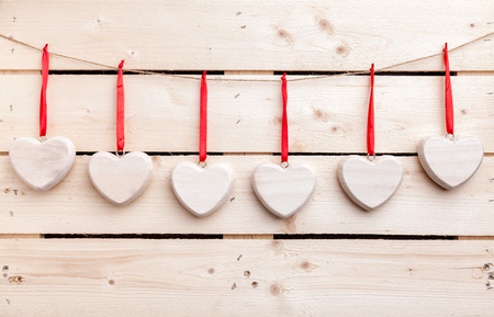 Love concept. Hearts hanging on a string, shot on wooden backgroundの写真素材