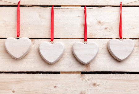 Love concept. Hearts hanging on a string, shot on wooden backgroundの写真素材