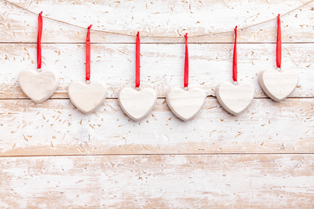 Love concept. Hearts hanging on a string, shot on wooden backgroundの写真素材