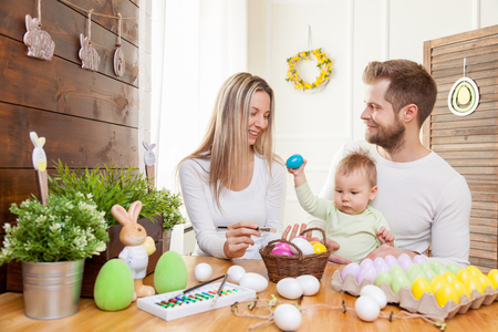 Easter concept. Happy and loving mother and father preparing home decoration with their child for Easter holidaysの写真素材