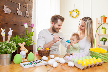 Easter concept. Happy and loving mother and father preparing home decoration with their child for Easter holidaysの写真素材