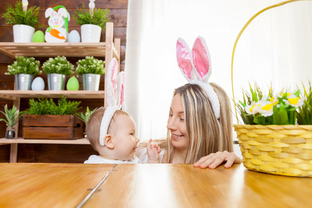 Easter concept. Happy mother and her cute child wearing bunny ears getting ready for Easterの写真素材