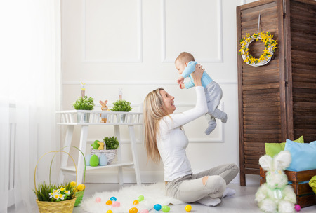 Delighted mother and her little child enjoying the Easter egg hunt at homeの写真素材
