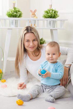 Delighted mother and her little child enjoying the Easter egg hunt at homeの写真素材
