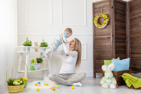 Delighted mother and her little child enjoying the Easter egg hunt at homeの写真素材