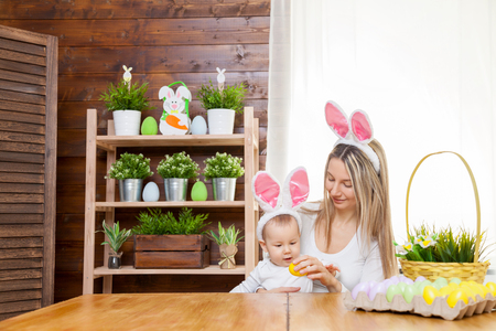 Easter concept. Happy mother and her cute child wearing bunny ears getting ready for Easterの写真素材