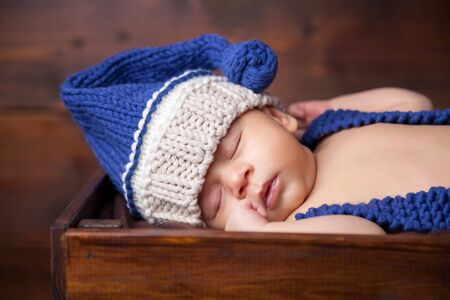 Sweet little newborn sleeps inside a wooden crateの写真素材
