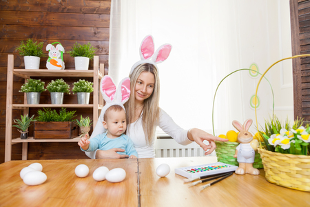 Easter concept. Happy mother and her cute child wearing bunny ears getting ready for Easterの写真素材
