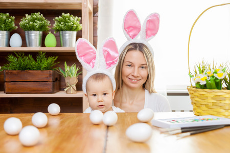 Easter concept. Happy mother and her cute child wearing bunny ears getting ready for Easterの写真素材