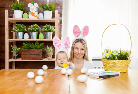 Easter concept. Happy mother and her cute child wearing bunny ears getting ready for Easterの写真素材
