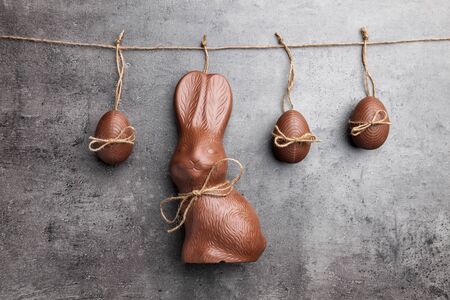 Delicious traditional Easter chocolate bunny and eggs hanging on a string