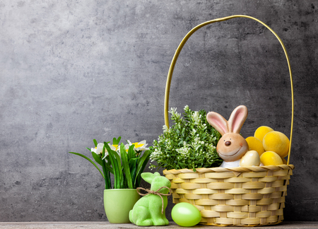Traditional Easter holiday basket with a bunny, eggs and flowersの写真素材