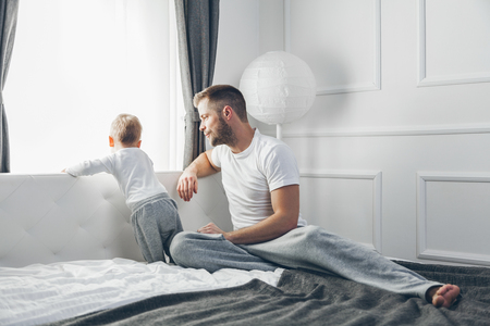 Happy father with his son looking out of the windowの写真素材