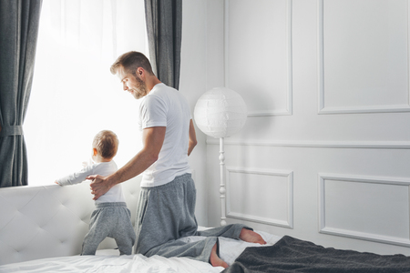 Happy father with his son looking out of the windowの写真素材