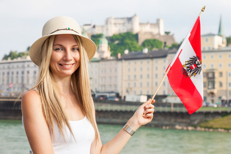A female tourist on vacation in Salzburg Austria holding the Austrian flagの写真素材