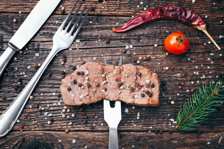 Delicious grilled beef steak with seasoning on wooden backgroundの写真素材