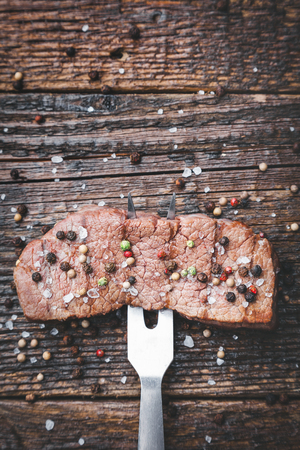 Delicious grilled beef steak with seasoning on wooden backgroundの写真素材