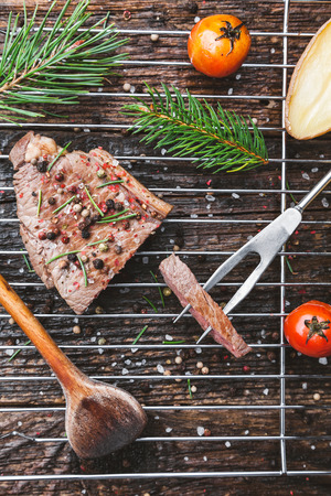 Delicious grilled beef steak with seasoning on wooden backgroundの写真素材