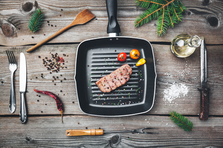 Delicious grilled beef steak with seasoning on wooden backgroundの写真素材