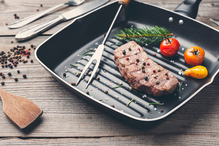 Delicious grilled beef steak with seasoning on wooden backgroundの写真素材