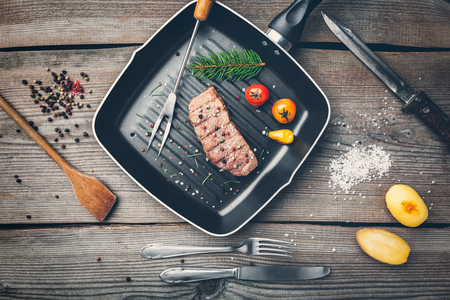 Delicious grilled beef steak with seasoning on wooden backgroundの写真素材