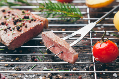 Delicious grilled beef steak with seasoning on wooden backgroundの写真素材
