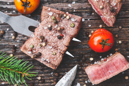 Delicious grilled beef steak with seasoning on wooden backgroundの写真素材