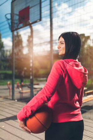 Young female basketball player training outdoors on a local courtの写真素材