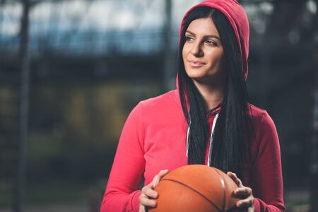 Young female basketball player training outdoors on a local courtの写真素材