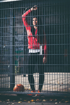 Young female basketball player training outdoors on a local courtの写真素材