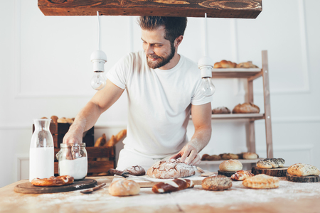 Baker with a variety of healthy and delicious freshly baked bread and pastryの写真素材