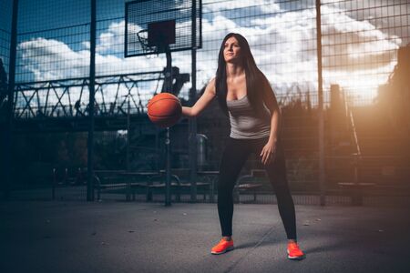 Young female basketball player training outdoors on a local courtの写真素材