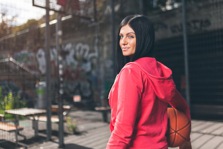 Young female basketball player training outdoors on a local courtの写真素材