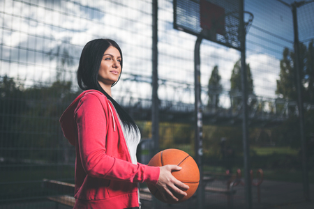 Young female basketball player training outdoors on a local courtの写真素材