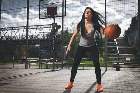 Young female basketball player training outdoors on a local courtの写真素材