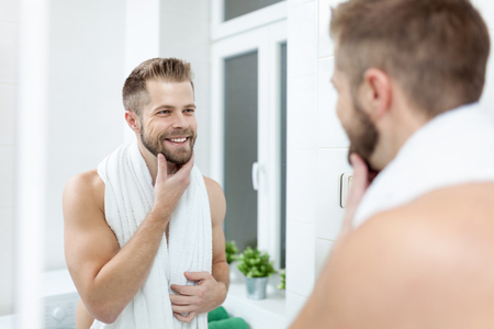Morning hygiene, Handsome man in the bathroom looking in mirrorの写真素材